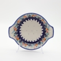 Round baking dish with handles made of Boleslawiec pottery.
