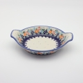 Round baking dish with handles made of Boleslawiec pottery.