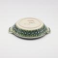 Round baking dish with handles made of Boleslawiec pottery.