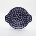 Round baking dish with handles made of Boleslawiec pottery.