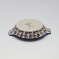 Round baking dish with handles made of Boleslawiec pottery.