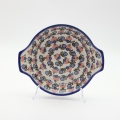 Round baking dish with handles made of Boleslawiec pottery.