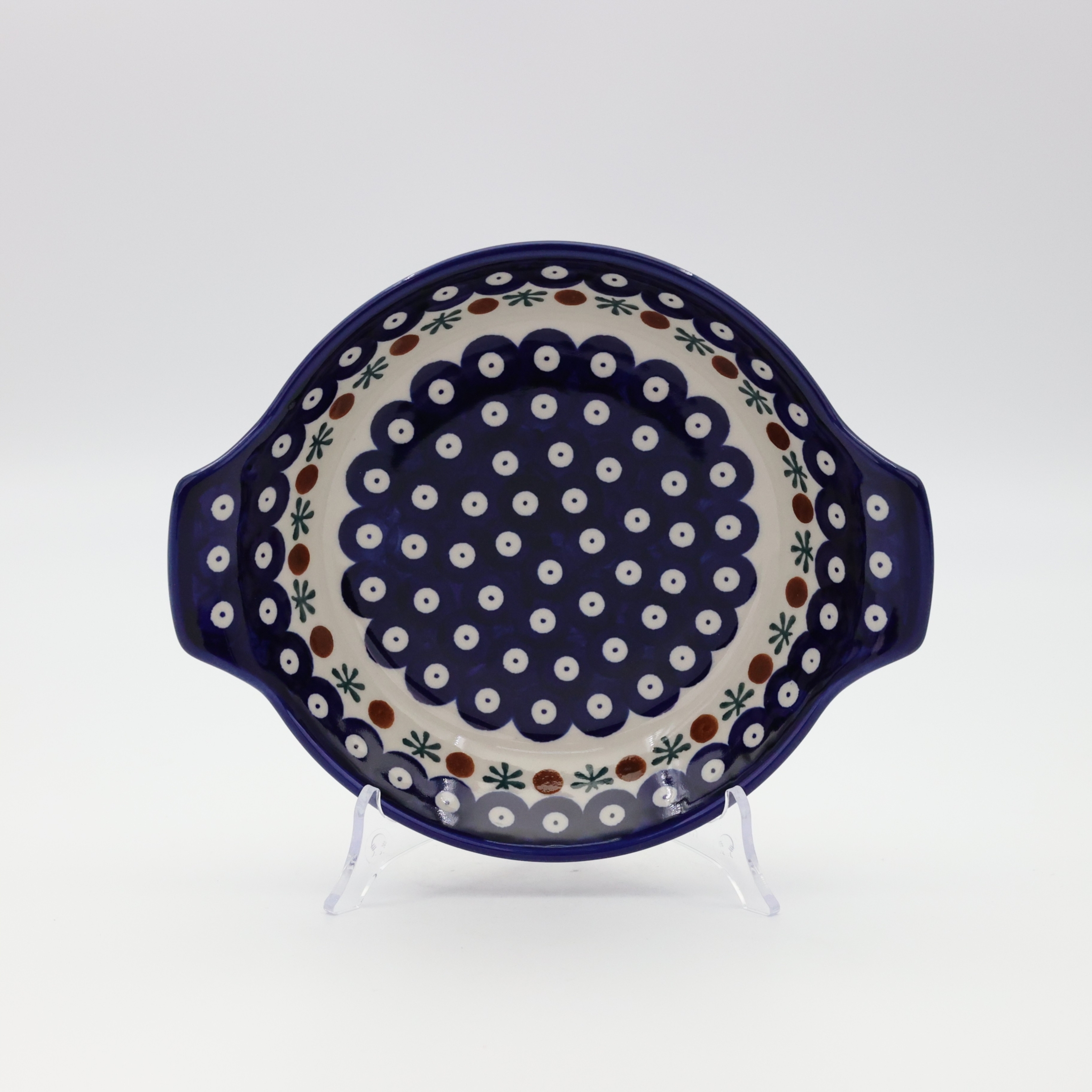 Round baking dish with handles made of Boleslawiec pottery.