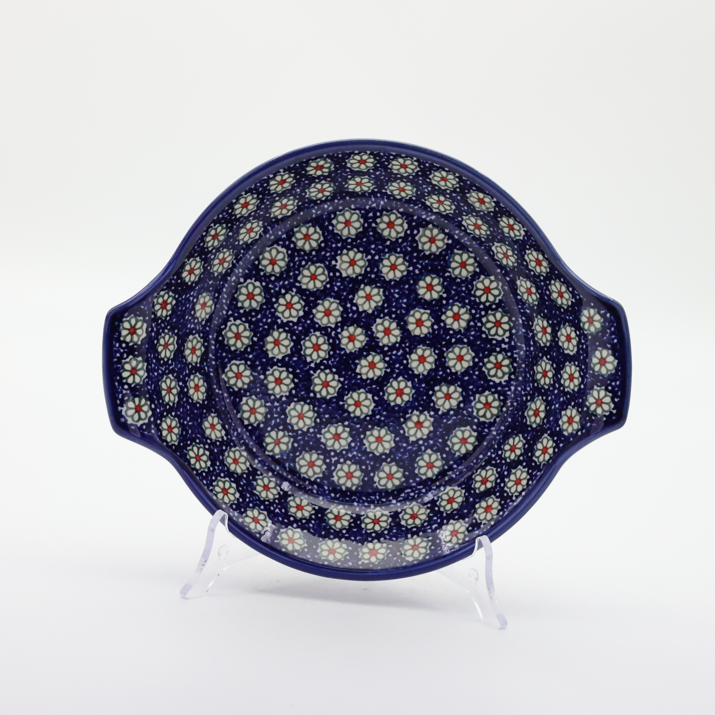 Round baking dish with handles made of Boleslawiec pottery.