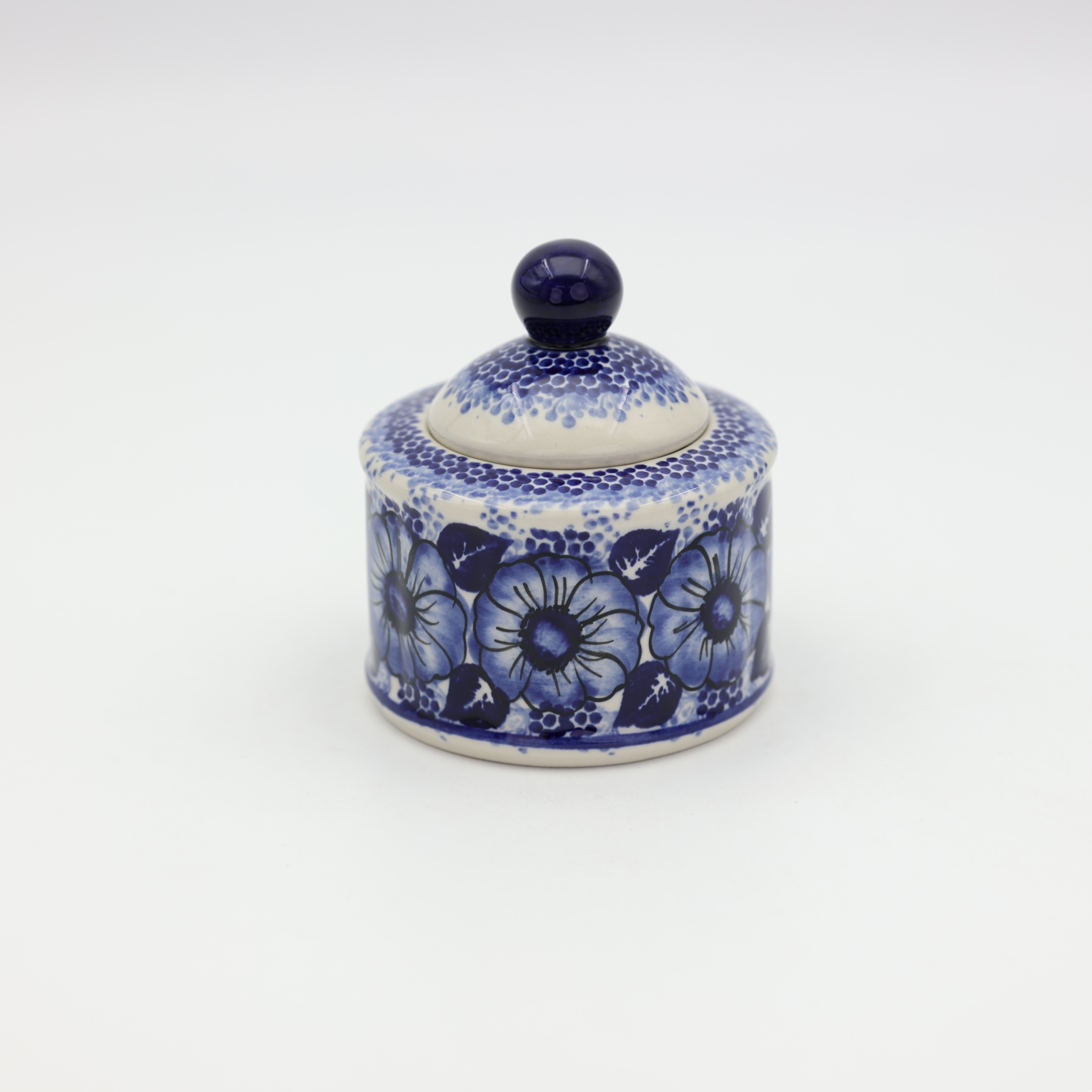 Boleslawiec ceramic sugar bowl with lid on table – traditional Polish tableware.